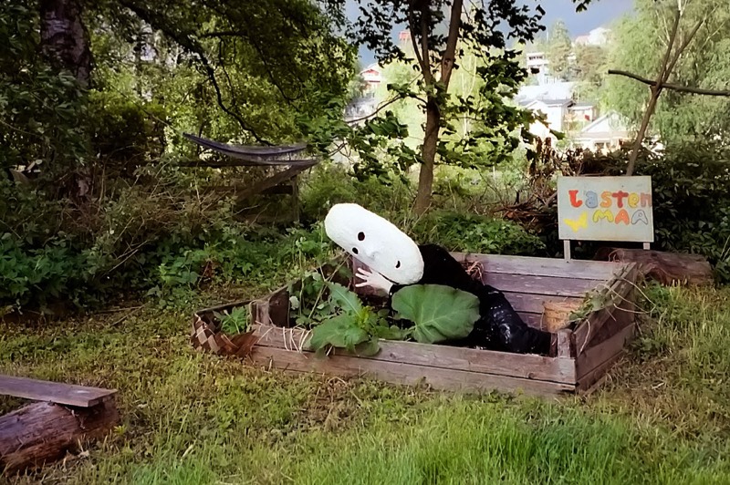 Osku Leinonen butoh-esityksessä tekemänsä naamion kanssa lähellä Kurpitsataloa, Tahmelassa Tampereella